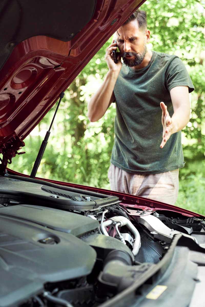 Junger Mann prüft Getriebeschaden bei Schrottauto Ankauf Oldenburg